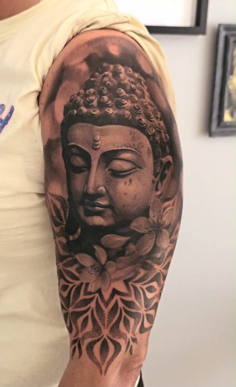 Tattoo: Buddha mit Mandala am Oberarm