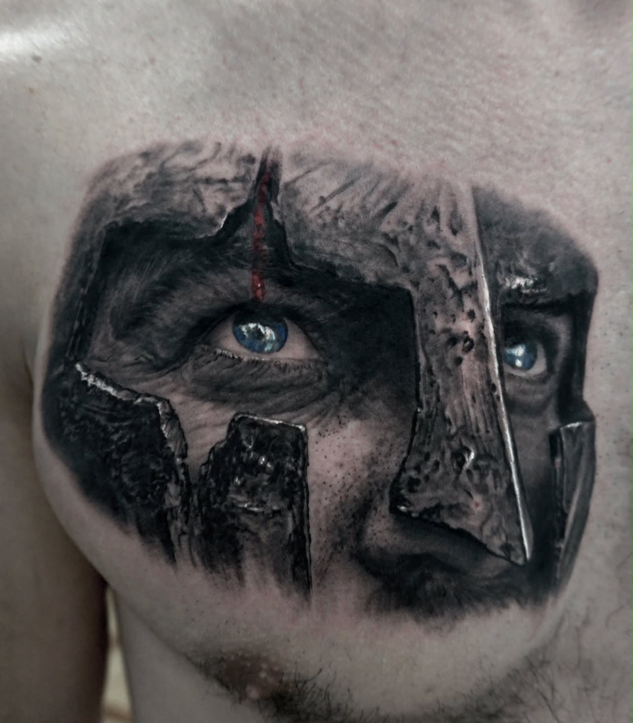 Tattoo: Gladiatorhelm mit blauen Augen auf der Brust
